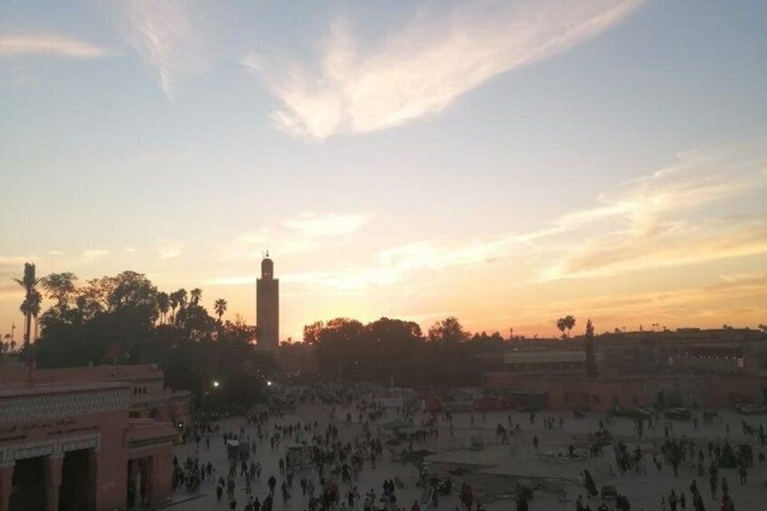 A large open square with a tall tower in the center, surrounded by buildings and trees. 5