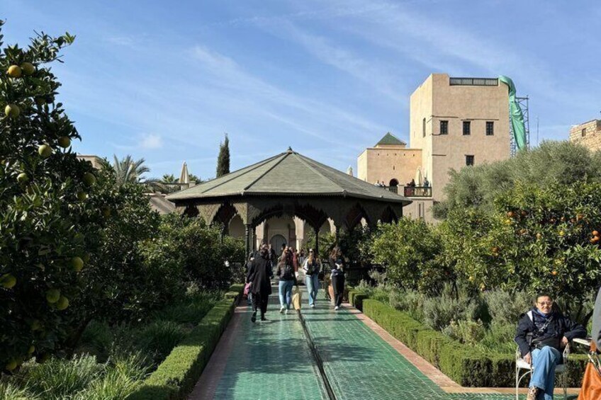A pathway leading to a building with a green roof, surrounded by greenery and a clear sky. 1