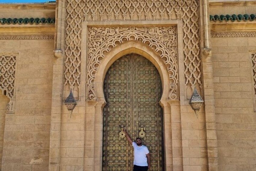 A person standing in front of a large, ornate door with intricate carvings and a green door knocker. 4