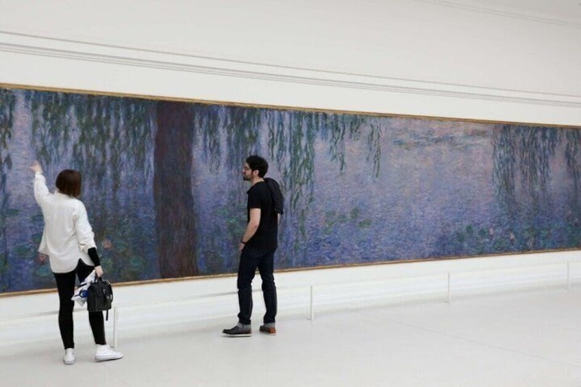 Two people observing a large painting in a gallery. 2