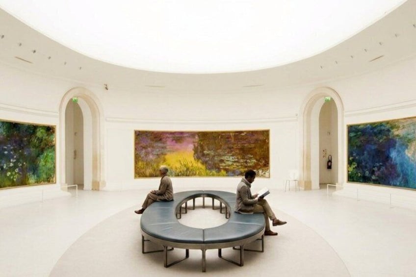 A modern art gallery with large paintings, a circular seating area, and a minimalist design. 3