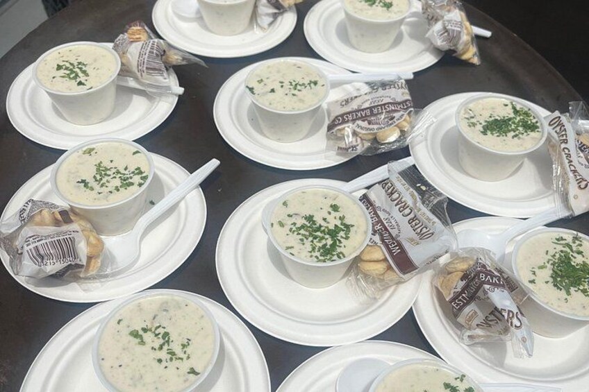 A table with multiple bowls of soup, each with a white spoon and garnished with herbs. 1