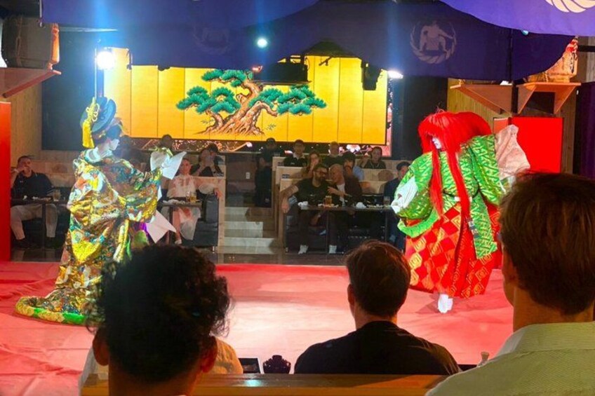 A traditional performance with performers in colorful costumes on a stage. 5