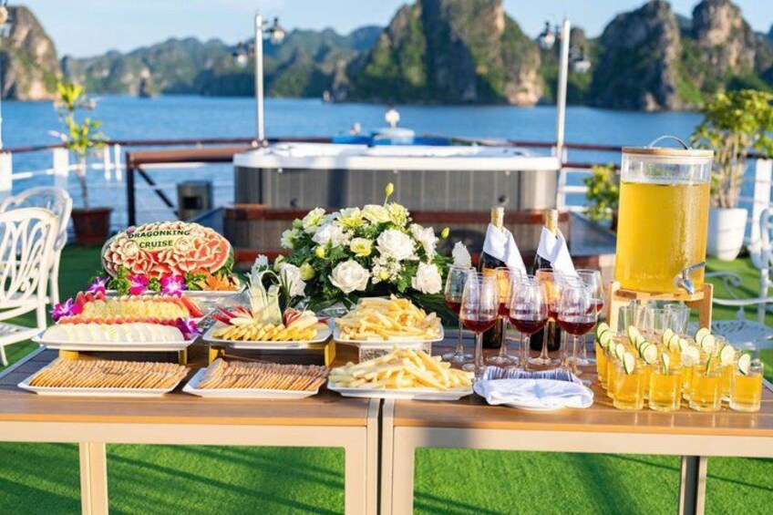 A table with food and drinks, a dragon boat, and a scenic coastal background. 5