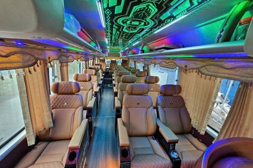 A train interior with leather seats, a central aisle, and a ceiling with a geometric pattern. 3