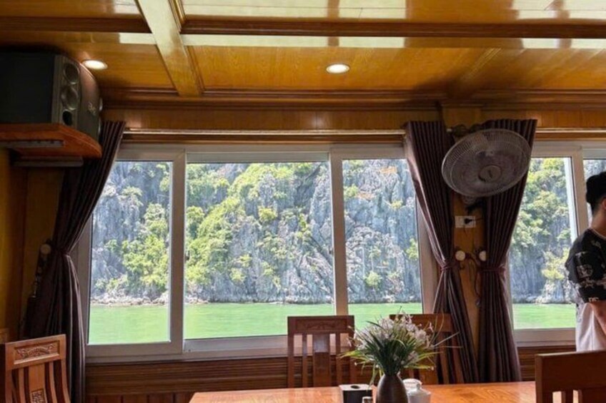 A dining area with a table, chairs, a fan, and curtains. 5