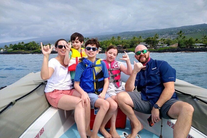 A group of people on a boat with water and a distant shoreline in the background. 2