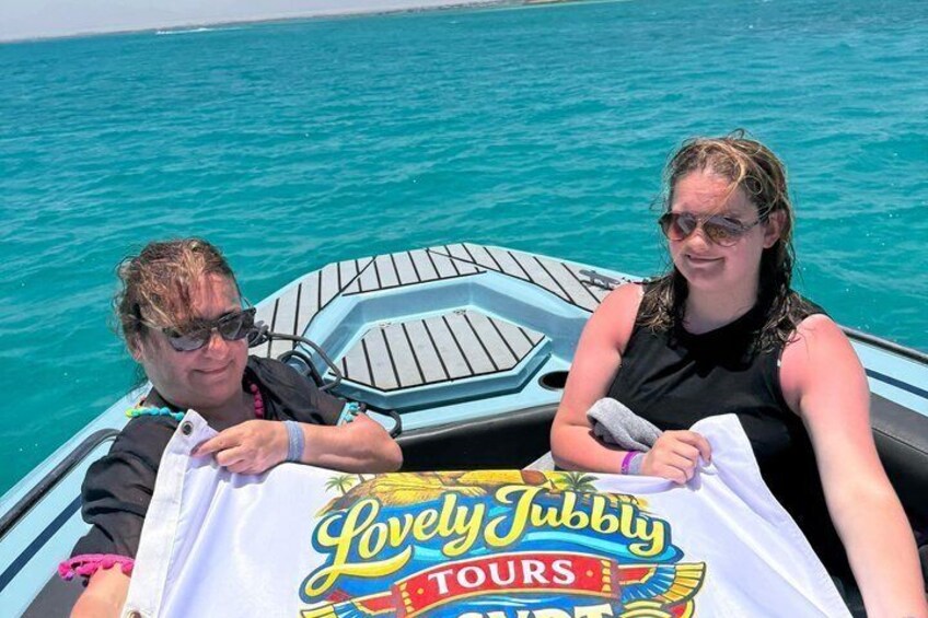 Two people on a boat with a 'Lovely Jubbly Tours' t-shirt. 4