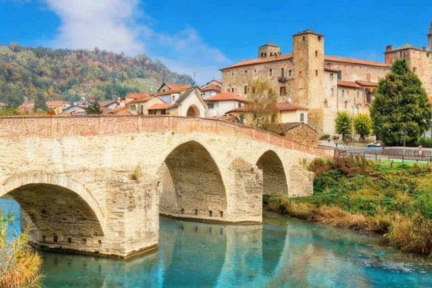 A stone bridge over a river, a castle in the background, and a hilly landscape. 5