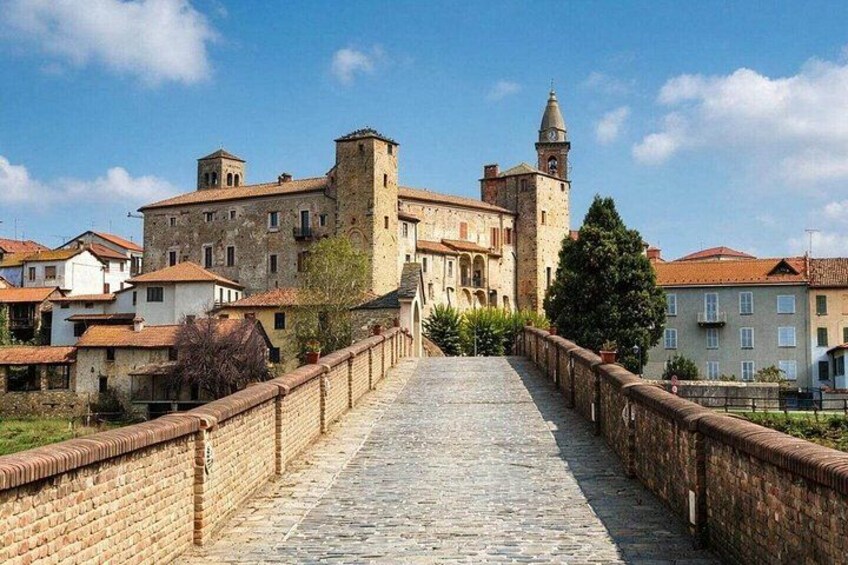 A stone bridge leading to a historic building with a tower. 4