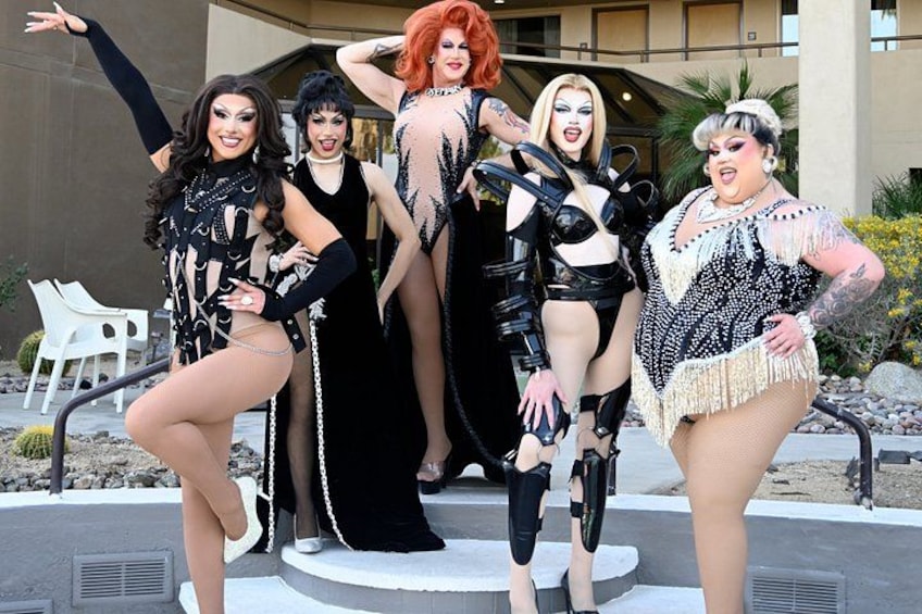 A group of people in costumes posing in front of a building. 2
