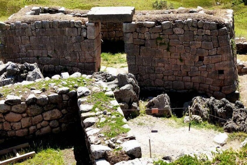 Ancient stone ruins with walls and a fenced area. 3