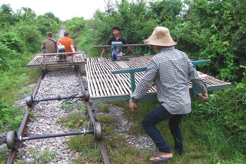 A person crossing a railway track using a makeshift bridge. 5