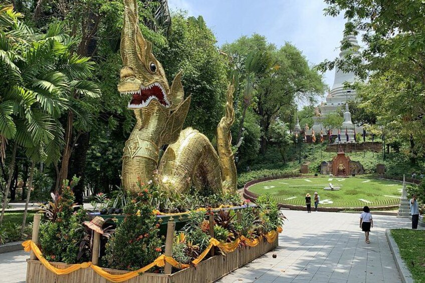 A large golden dragon sculpture in a park with a pagoda in the background. 3
