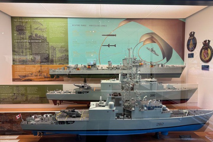 A naval ship model with a large bridge, gun turrets, and a flag. 4