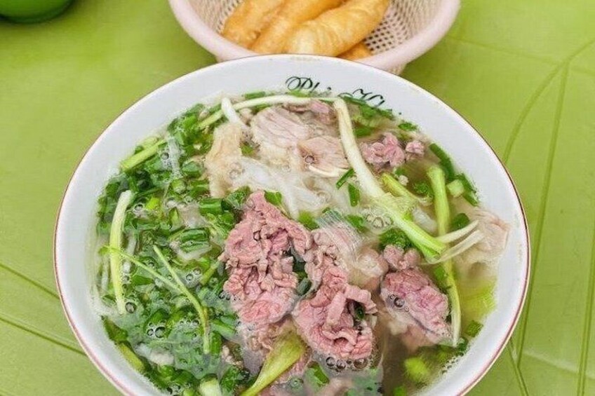 A bowl of soup with meat and vegetables. 1