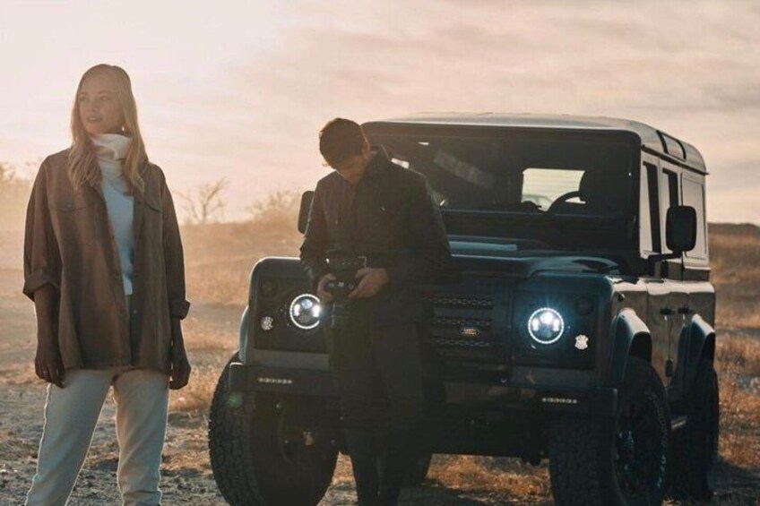 A vehicle with large tires and a person standing beside it. 2