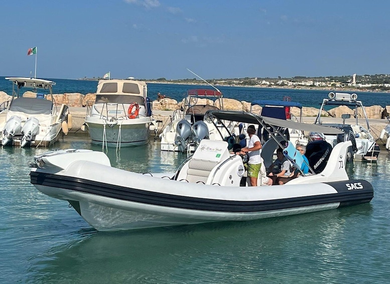 A small motorboat docked at a marina with several other boats. 2