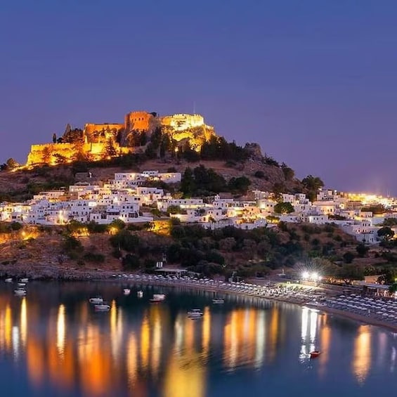 A coastal town at dusk with a prominent castle on a hill, illuminated buildings, and boats on the water. 3