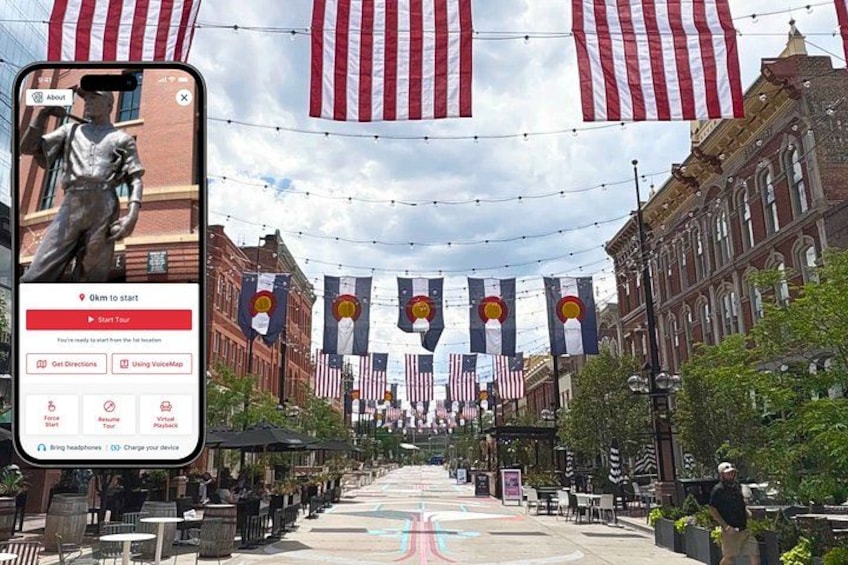 A street lined with American flags, a statue, and buildings with banners. 1