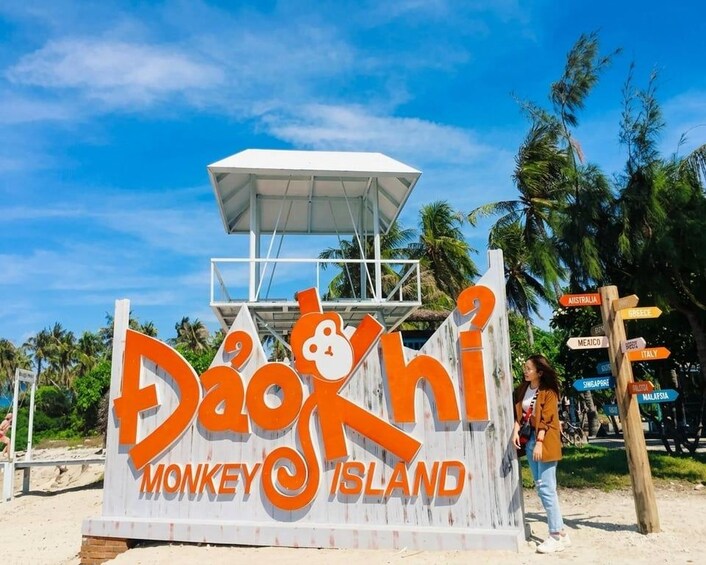 A sign for Dao Doki Monkey Island with a beach and palm trees in the background. 1