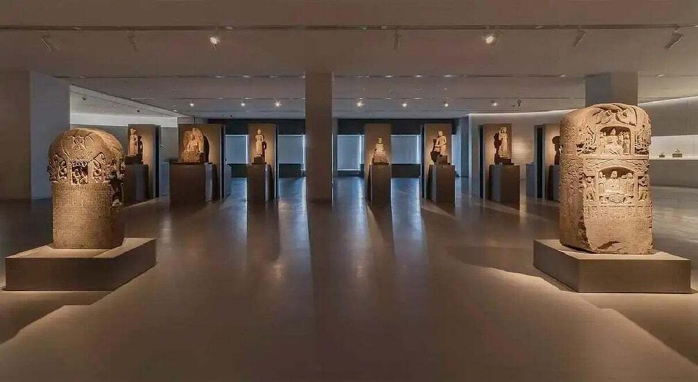 A museum interior with stone sculptures on pedestals. 5