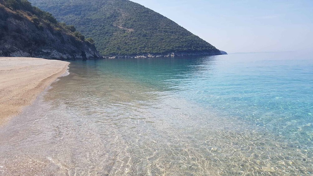 A clear beach with a sandy shore and a calm sea. 5