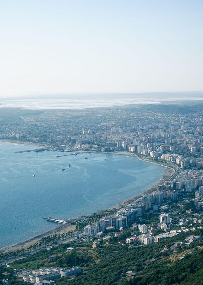 A coastal cityscape with a dense urban area, a marina, and a beach. 3