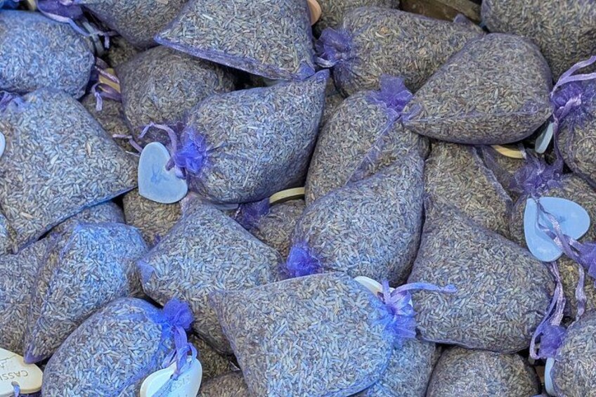 A collection of dried herbs tied with purple ribbons. 2