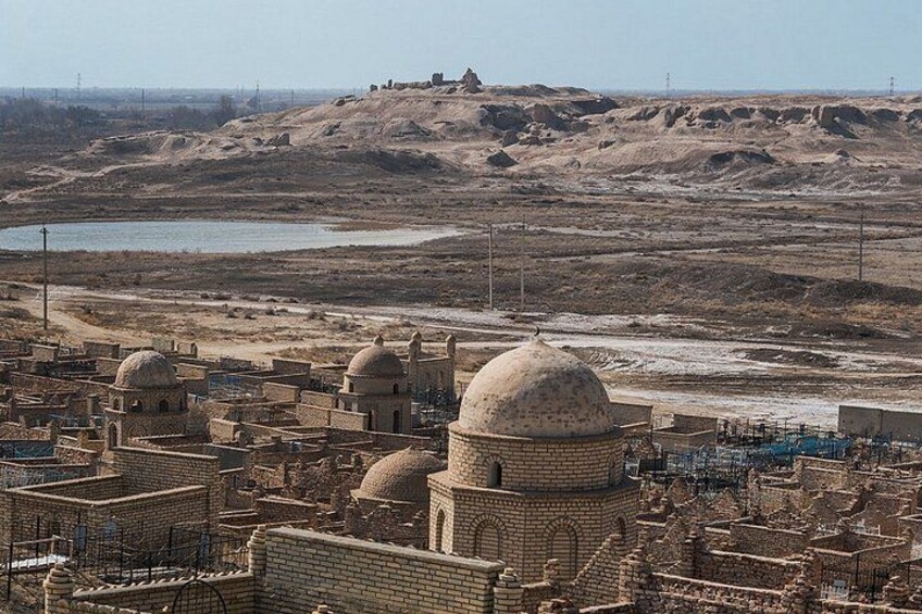 A desert landscape with ancient ruins and a distant hilltop structure. 3