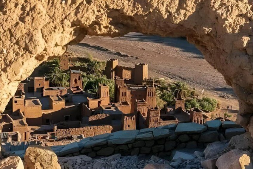 A model of a traditional village with adobe buildings, a stone wall, and a rocky landscape. 5