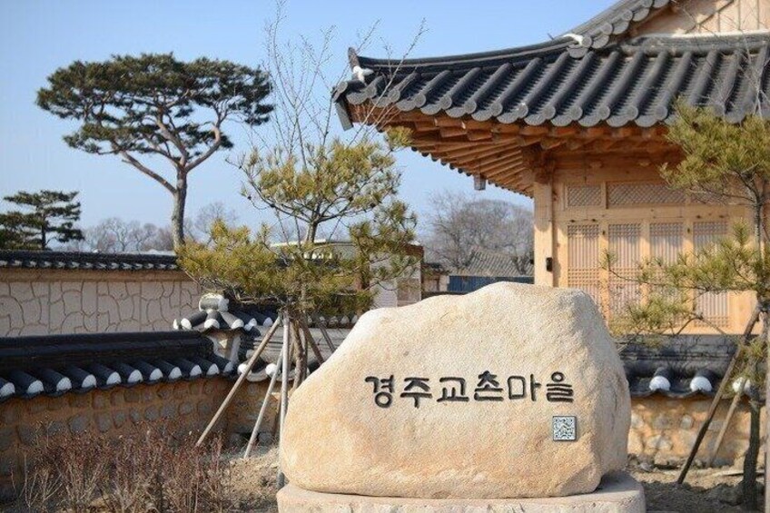 En traditionel koreansk bygning med et stensøjle foran. 3