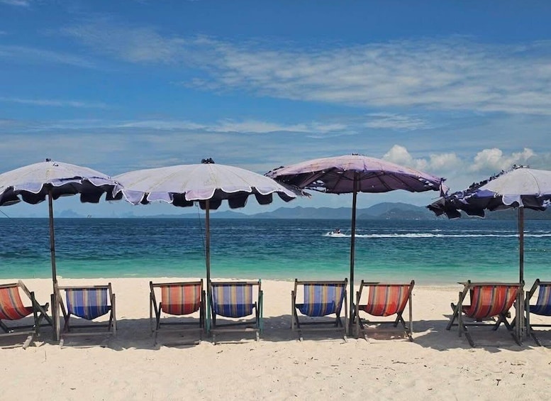 A beach with umbrellas and striped beach chairs. 5