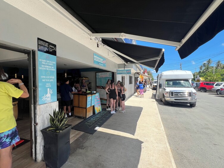 A bar and grill named Edelweiss #38 with a signboard, a group of people outside, and a parked truck. 3