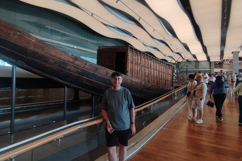A man standing in a modern building with a wooden structure and glass panels. 3