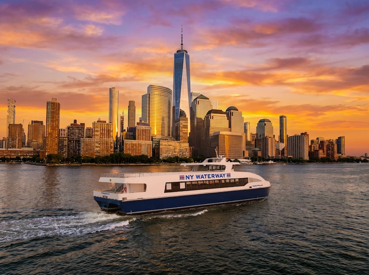 A NY Waterway boat on a river with a city skyline in the background. 4