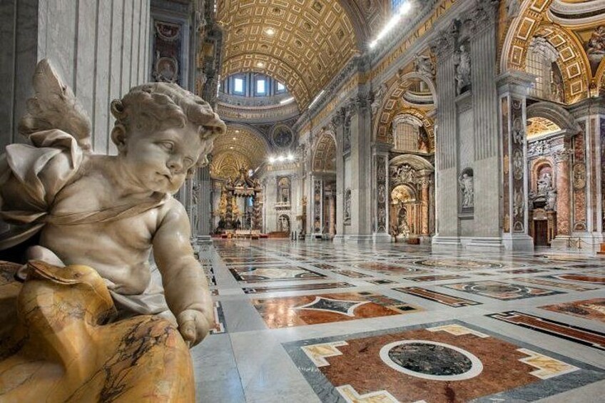 A grand hall with a marble floor, columns, and a statue of an angel. 2
