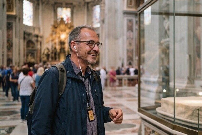 A person standing in a museum with glass display cases and marble floors. 5