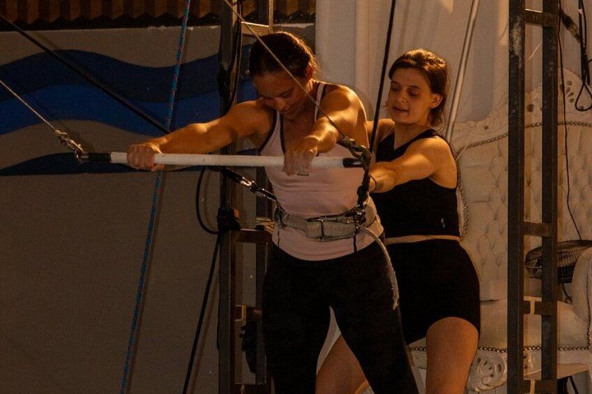 Deux personnes pratiquaient une activité physique, peut-être un entraînement ou des exercices, en utilisant du matériel comprenant une barre blanche et des cordes. 2