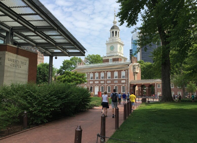 A Liberty Bell Center with a clock tower, surrounded by greenery and a paved walkway. 5