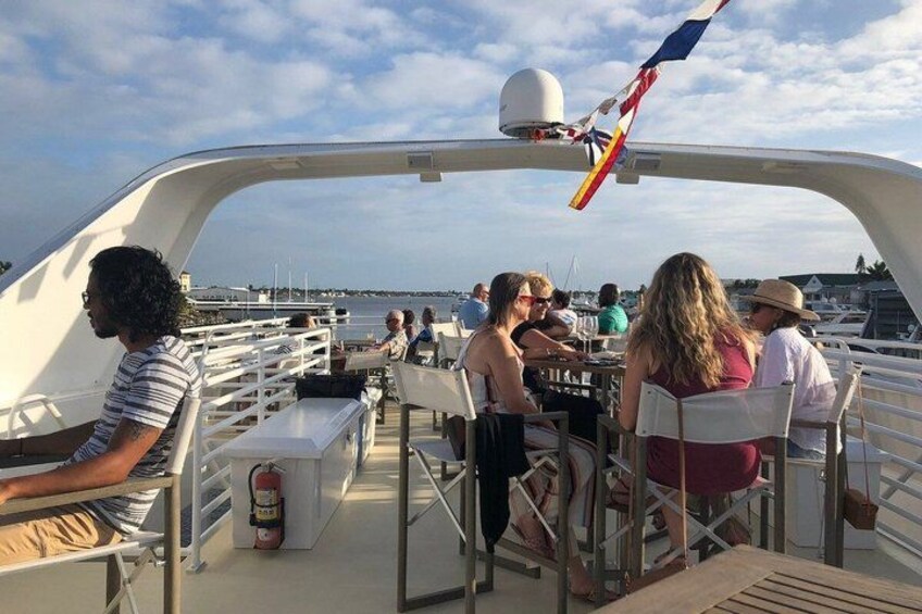A boat with people dining and a flag. 3