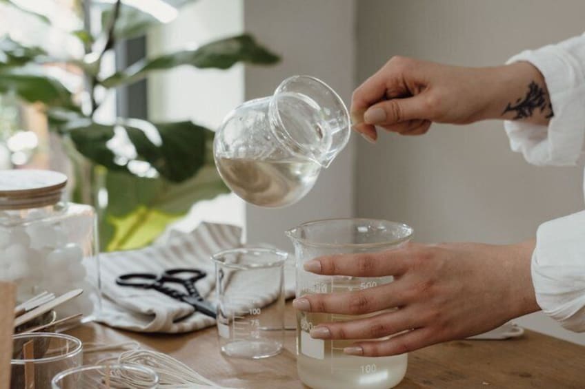 A person pouring a clear liquid into a measuring cup. 5