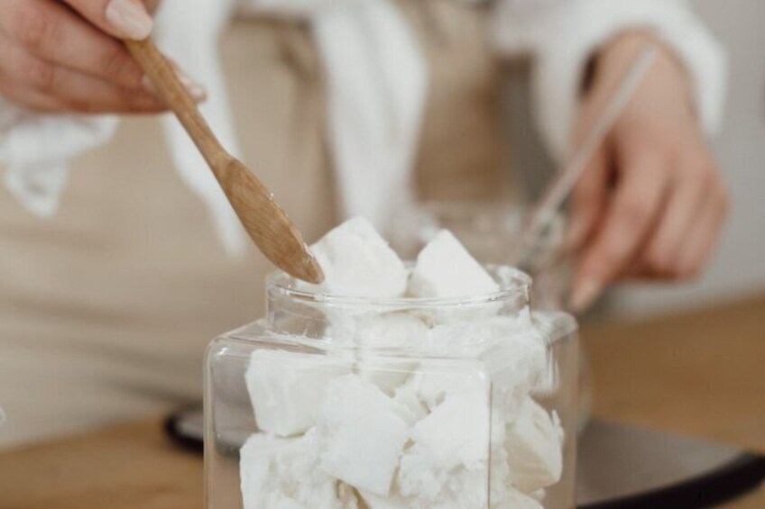 A person stirring white cubes in a transparent container. 4
