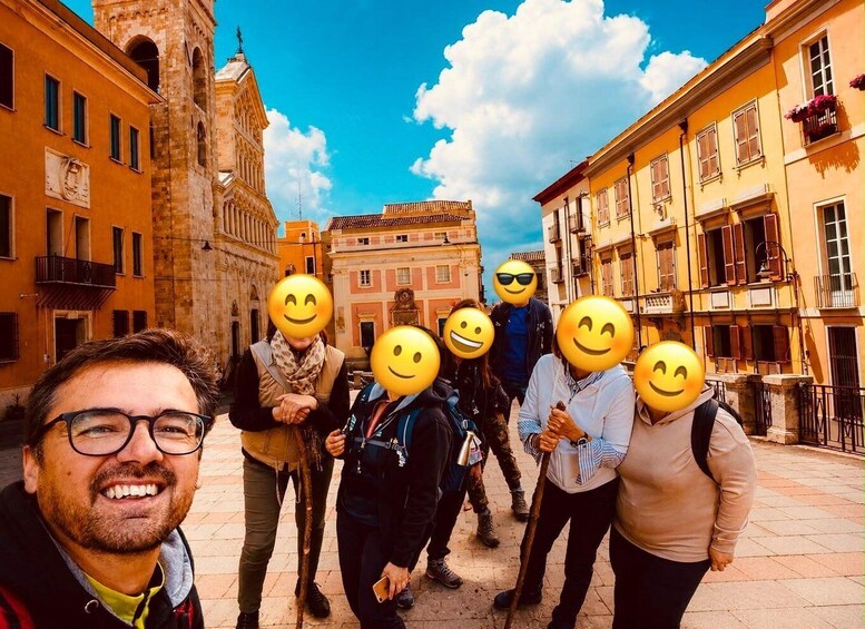 A group of people in a historic square with buildings and a tower. 3
