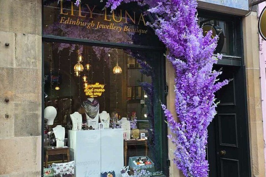 A storefront with a purple floral display and a sign reading 'Lily Luna Edinburgh Jewellery Boutique.' 2