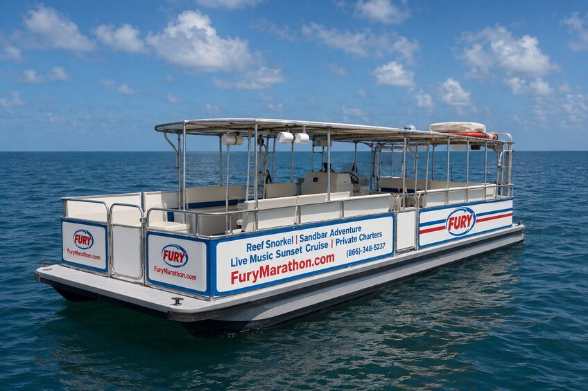 Ein Boot mit der Beschriftung 'FURY' und dem Schriftzug 'Reef Snorkel | Sandbar Adventure | Live Music Sunset Cruise | Private Charters' an der Seite. 2