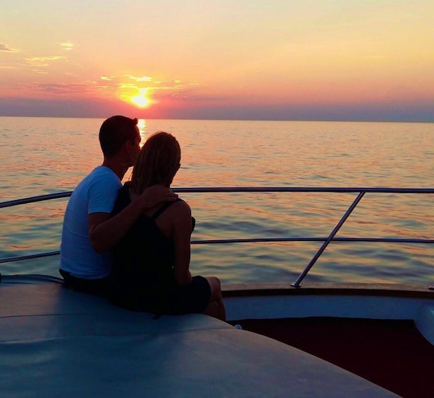 A couple sitting on a boat during sunset. 4