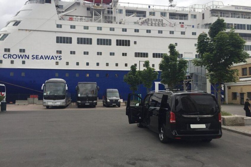 A large cruise ship named 'CROWN SEAWAYS' docked at a port with several vehicles and a pedestrian walkway. 4