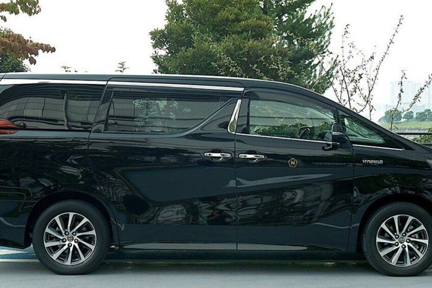 A black van parked on a road with trees in the background. 5