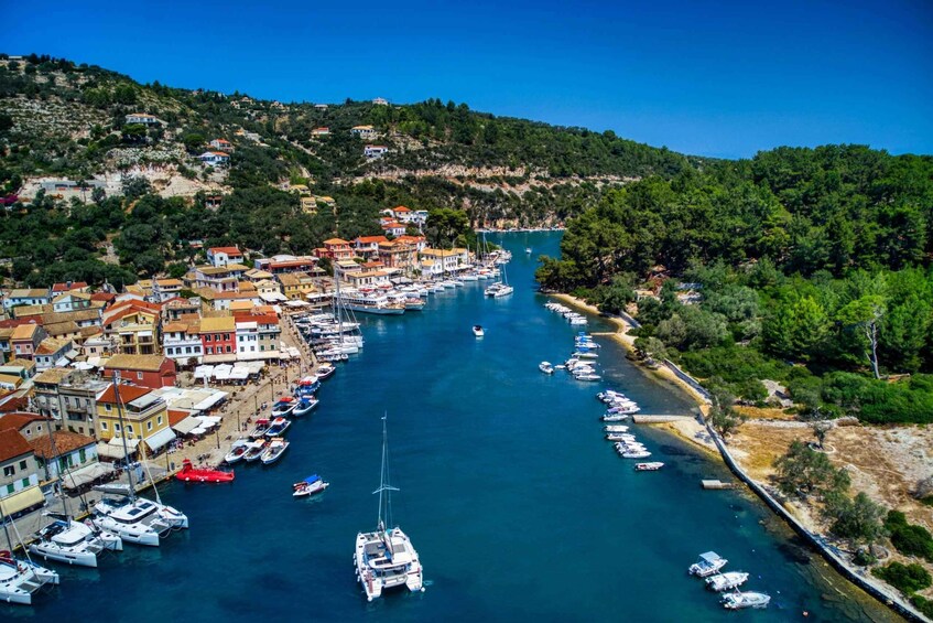 A coastal town with a marina filled with boats, surrounded by hills and dense greenery. 2